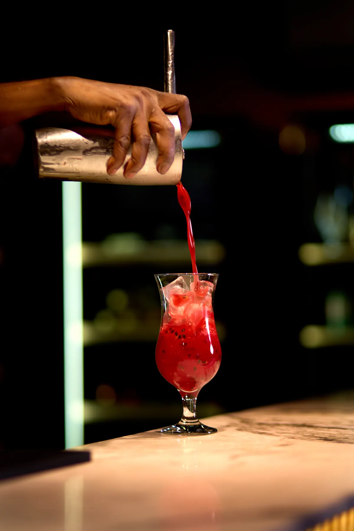 A bright red cocktail poured at Rye