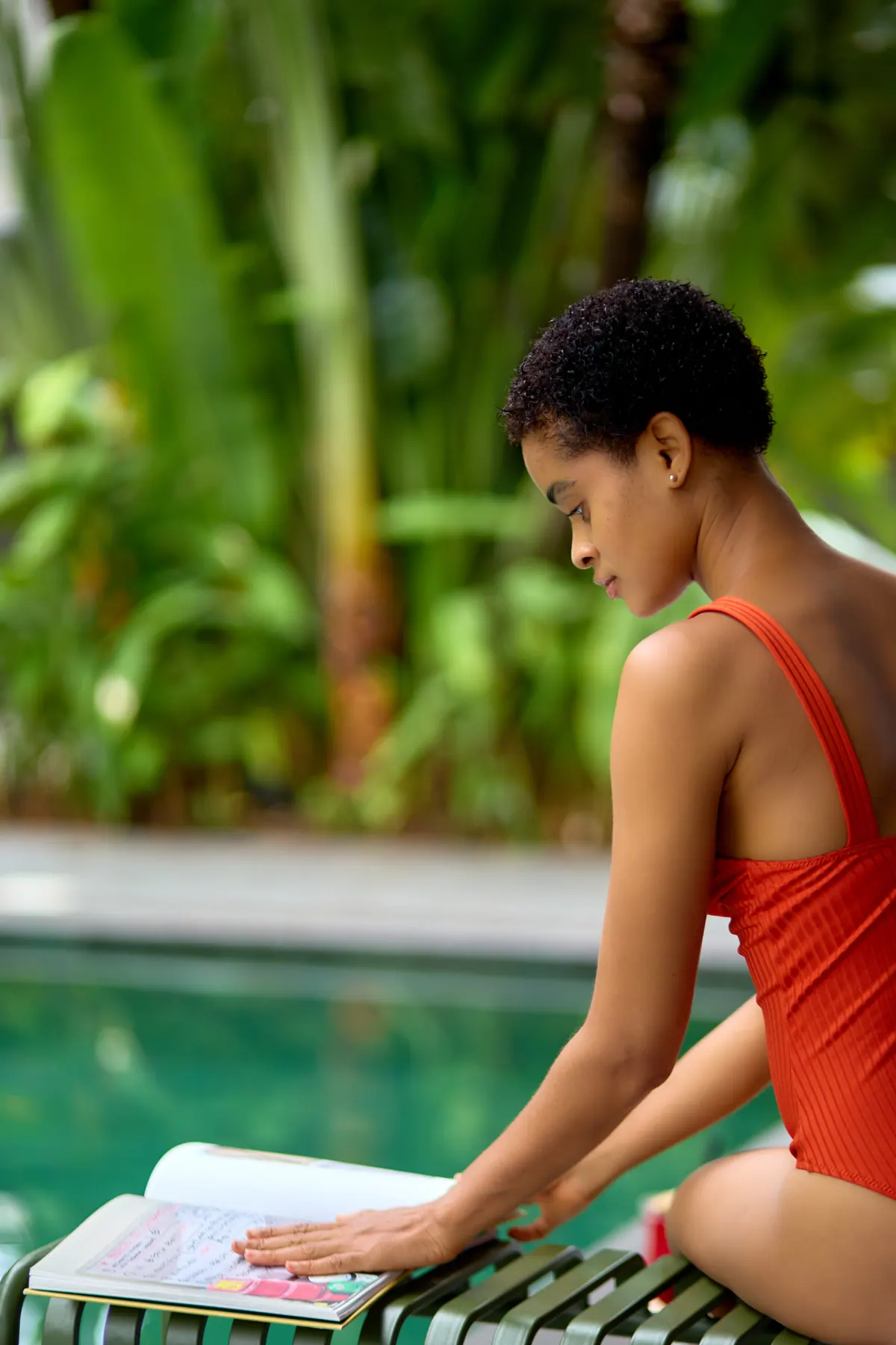 Guest reading beside the pool at Nordic Hotel Lagos